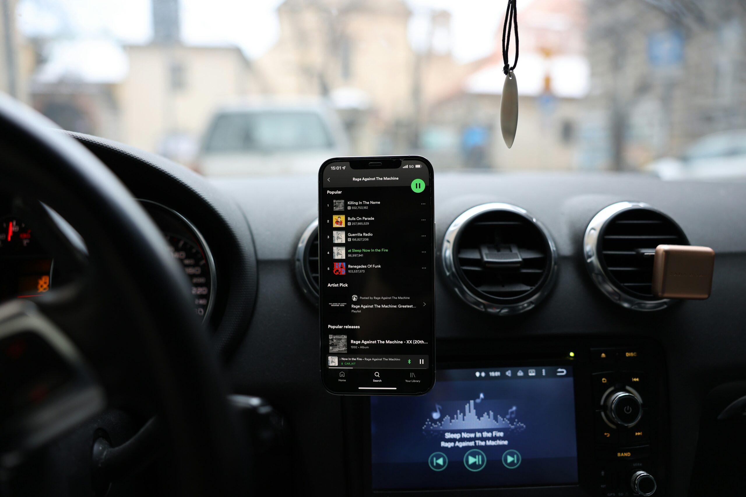 mobile phone on hands free in car, showing Spotify app